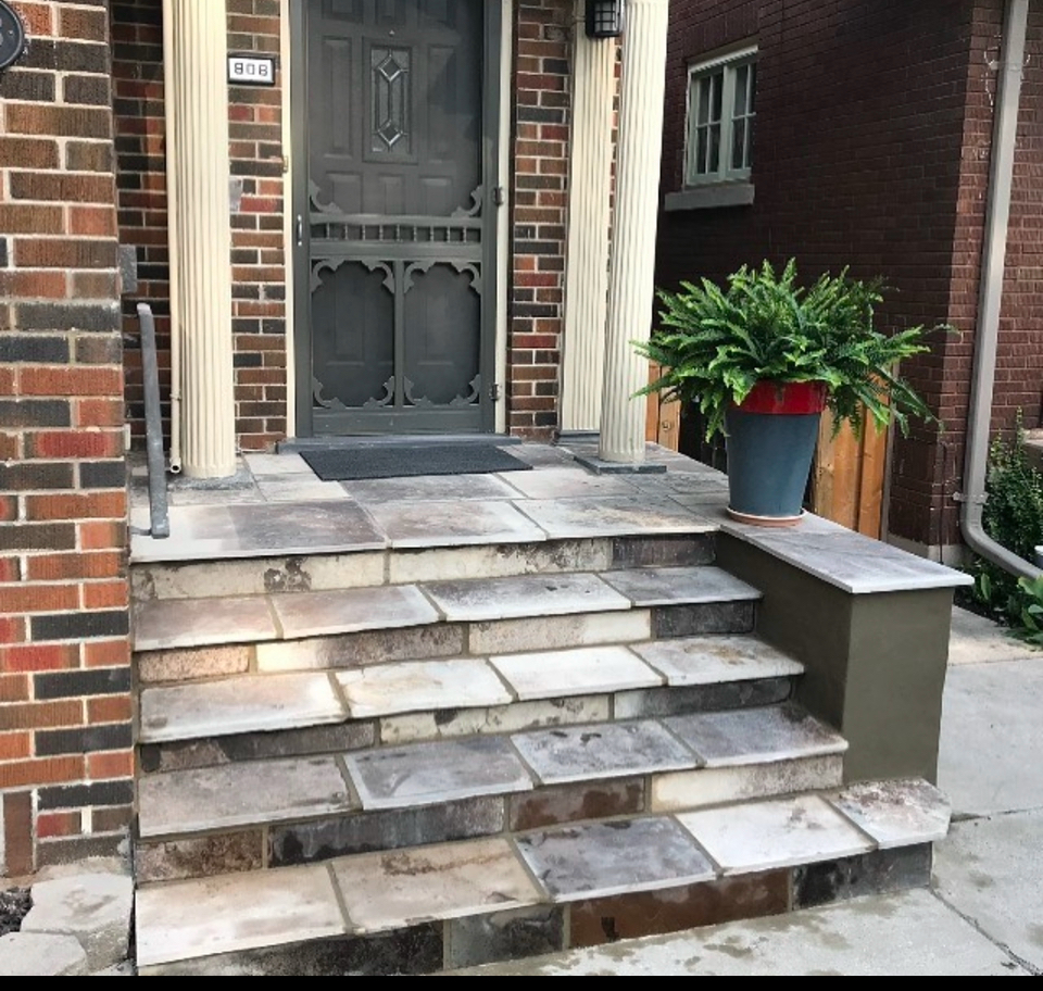 Front entry steps and porch before restoration showing stained and mismatched stonework in London Ontario
